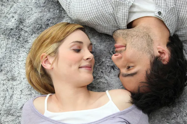 Couple lying on carpet — Stock Photo, Image