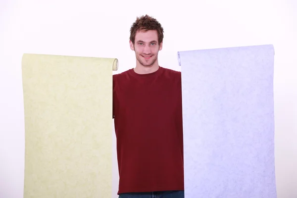 Homem segurando duas tiras de papel de parede — Fotografia de Stock