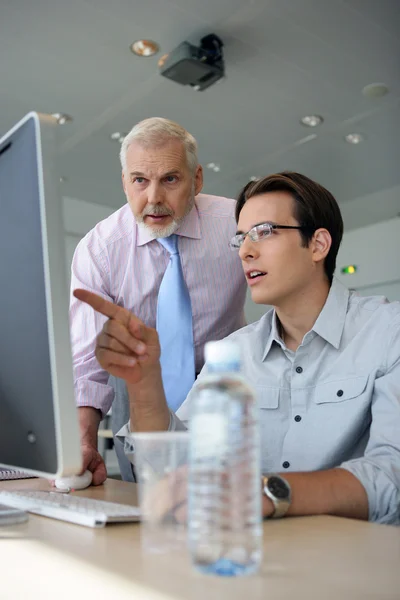 Young businessmen explaining point to boss — Stock Photo, Image