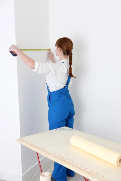 Женщина измеряет стену для обоев — стоковое фото