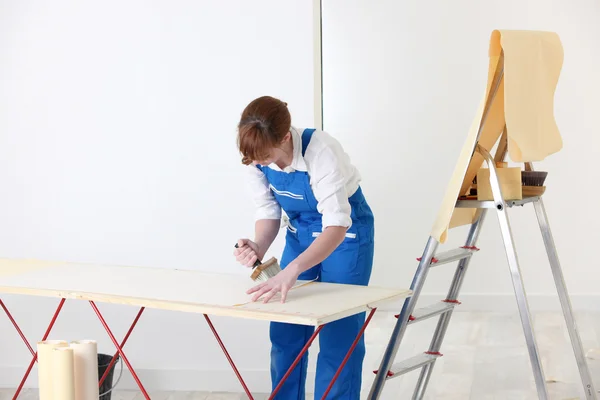 Vrouw ophangen van behang — Stockfoto