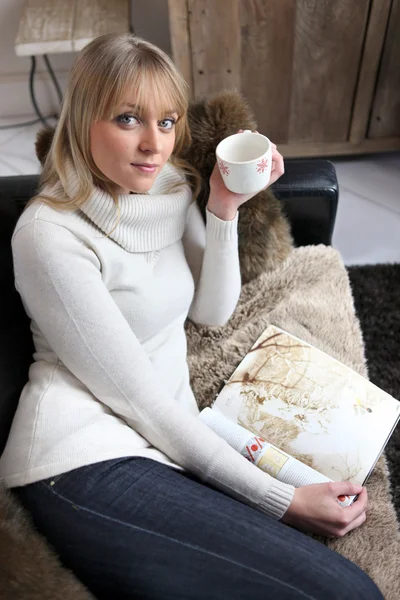 Mulher relaxante em um sofá — Fotografia de Stock