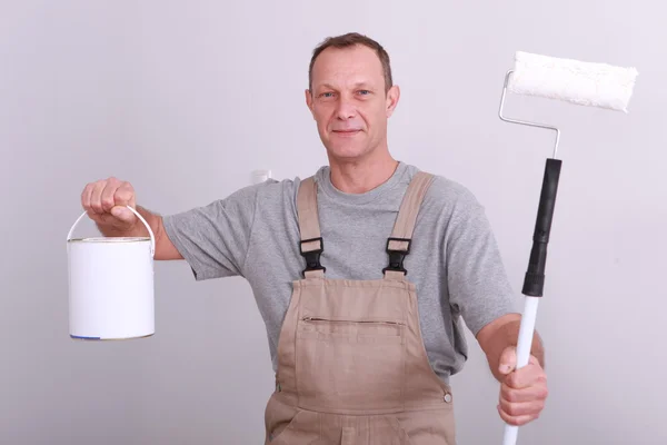 Hombre sosteniendo estaño de pintura blanca y rodillo — Foto de Stock