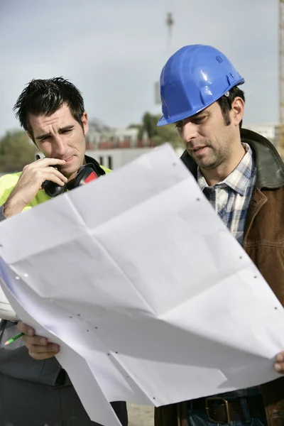 Foreman e colega verificando os planos — Fotografia de Stock