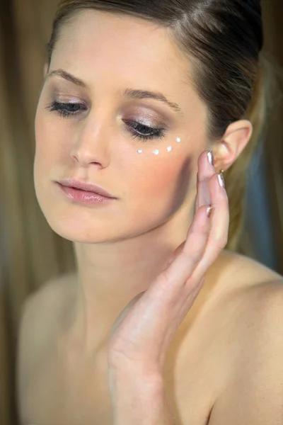 Woman applying cream on your face Stock Image
