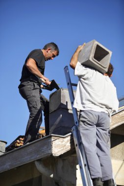 Two roofers hard at work clipart