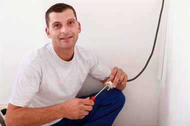 Portrait of young man working electrical wiring indoors clipart