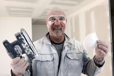 Handyman covered in dust after sanding room clipart