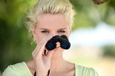 Woman with binoculars observing nature clipart