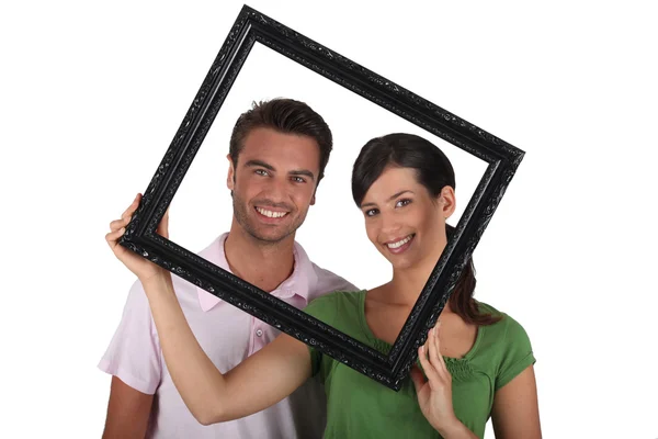 Silly couple with picture frame — Stock Photo, Image