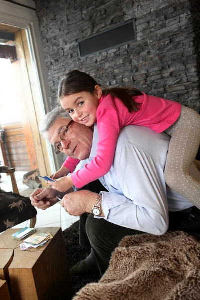 Grandfather and granddaughter playing a card game — Stock Photo, Image