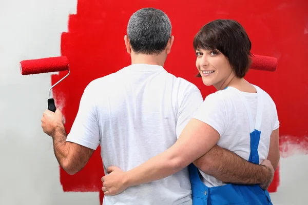 Couple painting wall in red — Stock Photo, Image