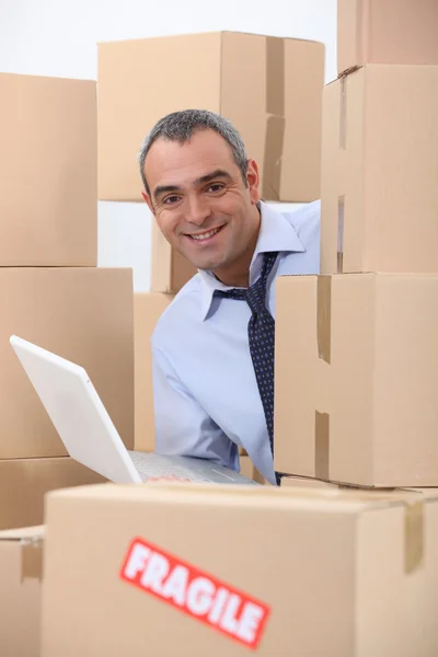 Homem com laptop nas caixas — Fotografia de Stock