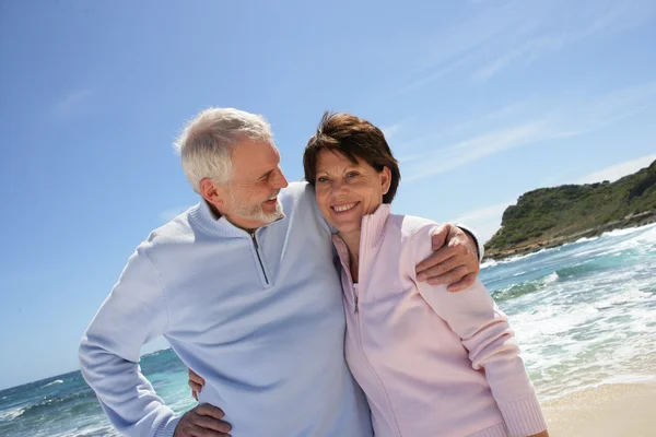 Starší pár, procházky po pláži — Stock fotografie