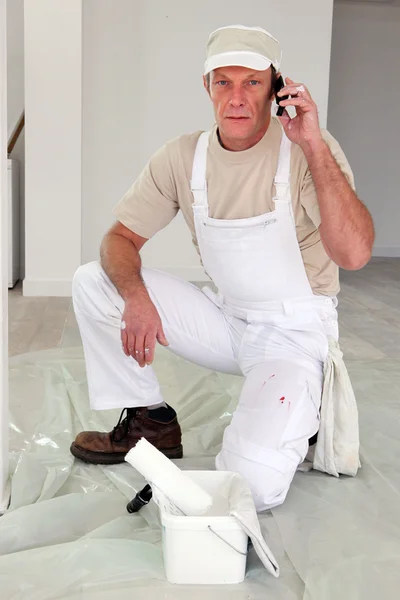 Pintor parando trabalho para fazer chamada para o fornecedor — Fotografia de Stock