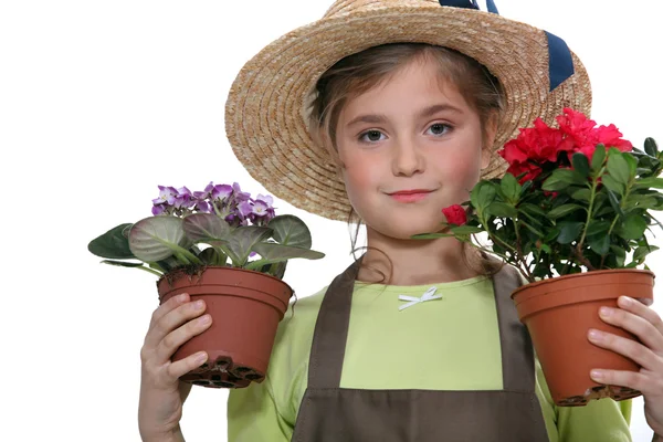 Kleines Mädchen hält zwei Pflanzen in Töpfen — Stockfoto