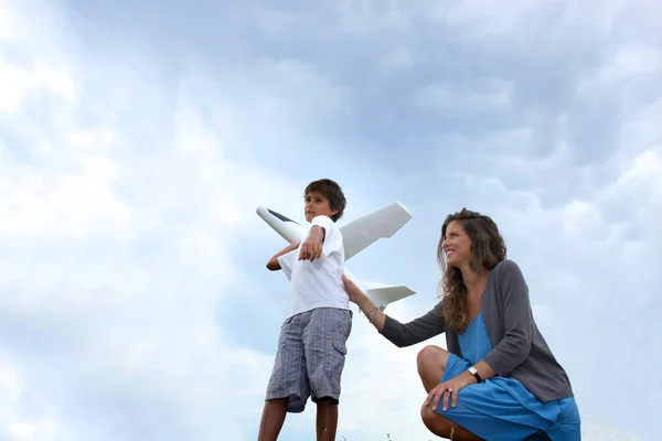 Moeder en zoon spelen met vliegtuig — Stockfoto