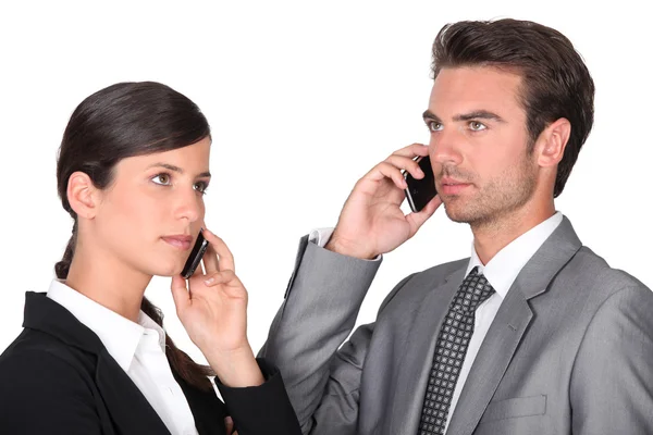 Hombre y mujer de negocios usando teléfonos celulares — Foto de Stock