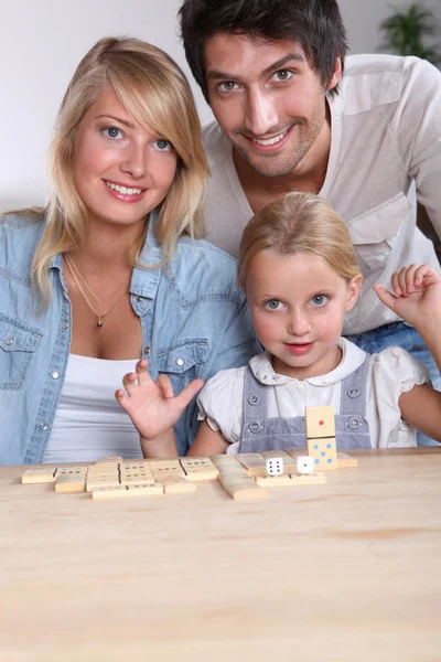 父母和女儿玩多米诺骨牌 — 图库照片