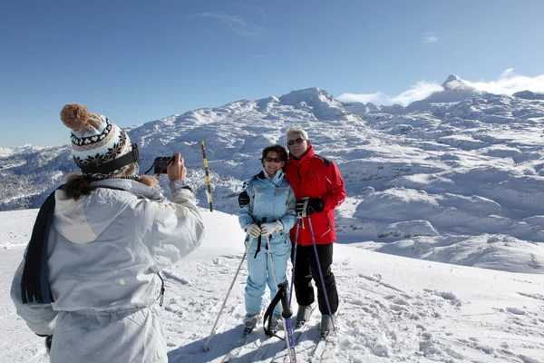 Esquiadores posando com a paisagem da montanha — Fotografia de Stock