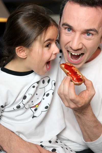 父と娘のプレッツェルを間食 — ストック写真