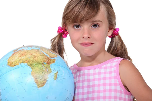 Молодая девушка с большим глобусом показывает Африку — стоковое фото