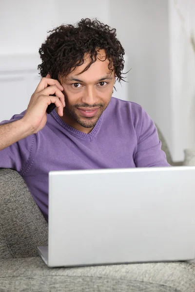 Homme avec ordinateur parlant au téléphone — Photo