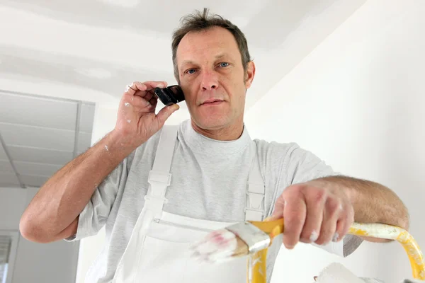 Decorator interrupted by phone call — Stock Photo, Image