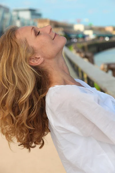 stock image Blond woman posing by port