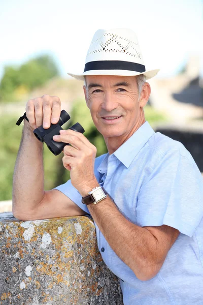 Senior man with a pair of binoculars — Stock Photo, Image