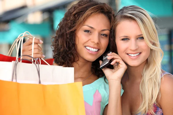 Vrienden uit winkelen met een mobiele telefoon — Stockfoto