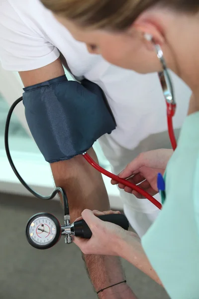 De arts die de bloeddruk van de patiënt neemt — Stockfoto