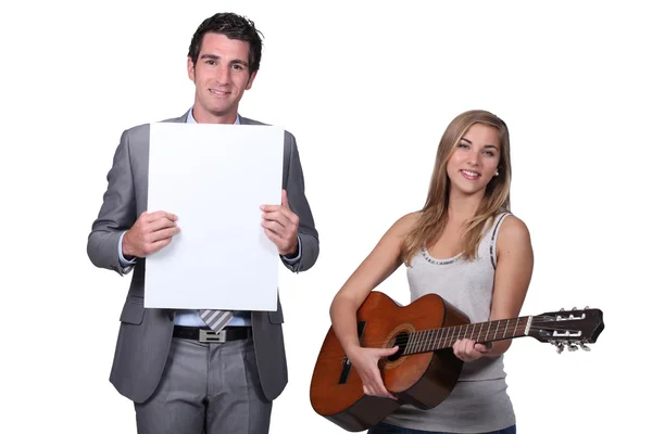 Chica adolescente jugando profesor de guitarra sosteniendo tablero de mensajes en blanco —  Fotos de Stock