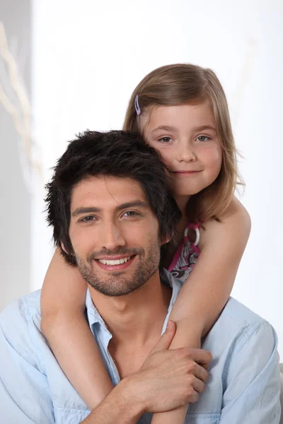 Young girl riding piggy-back on her father's back — Stock Photo, Image