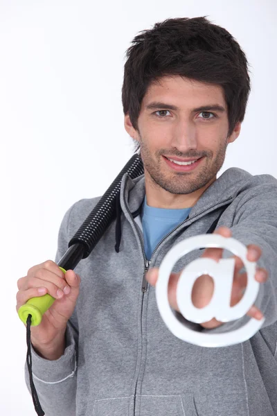 Uomo in ginnastica con un segno @ — Foto Stock