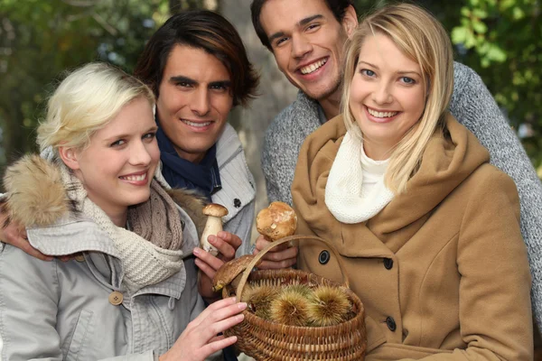 Group of young with a basket of chestnuts and mushrooms — Stock Photo, Image