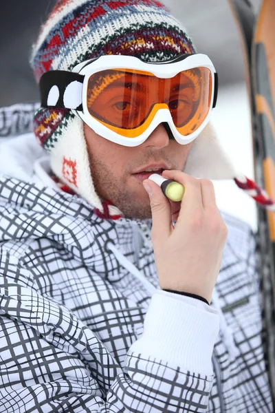 Skier applying lip balm — Stok fotoğraf