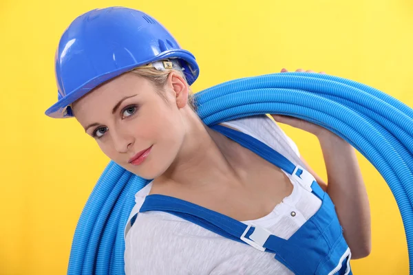 Blond plumber carrying plastic piping — Stock Photo, Image