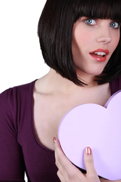 Kalp şeklinde bir kutu tutan genç kadın — Stok fotoğraf