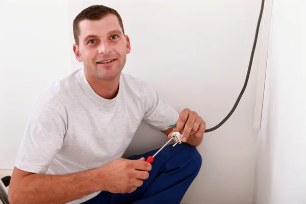 Portret van een jonge man die werkt elektrische bedrading binnenshuis — Stockfoto