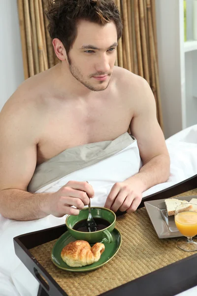 Man äter frukost i sängen — Stockfoto