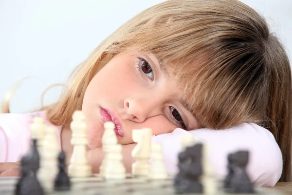 Menina entediada jogando xadrez — Fotografia de Stock