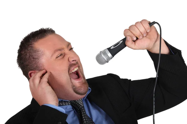 Portrait of a man screaming into a microphone — Stock Photo, Image