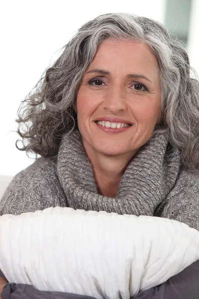 Женщина средних лет обнимает подушку — стоковое фото