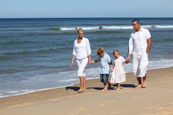 Семья с детьми, гуляющими по пляжу — стоковое фото