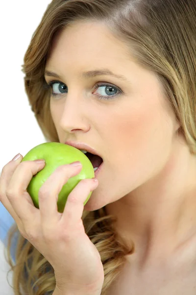 Девушка ест хрустящее зеленое яблоко — стоковое фото