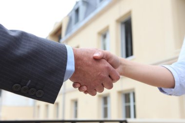 Close-up of man and woman shaking-hands outdoors clipart