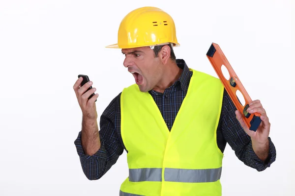 Irate builder shouting down phone — Stock Photo, Image