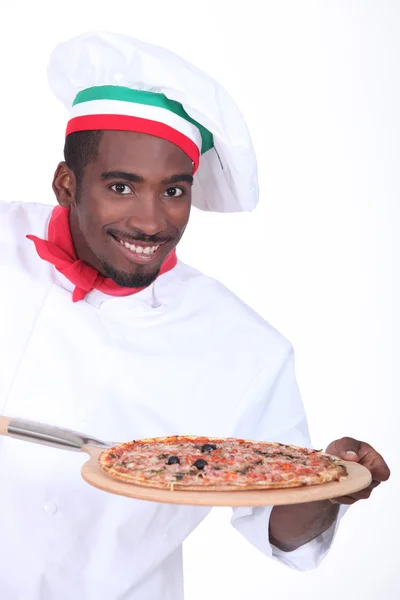 Şef pizza üzerine bir tahta kabuğu ile — Stok fotoğraf