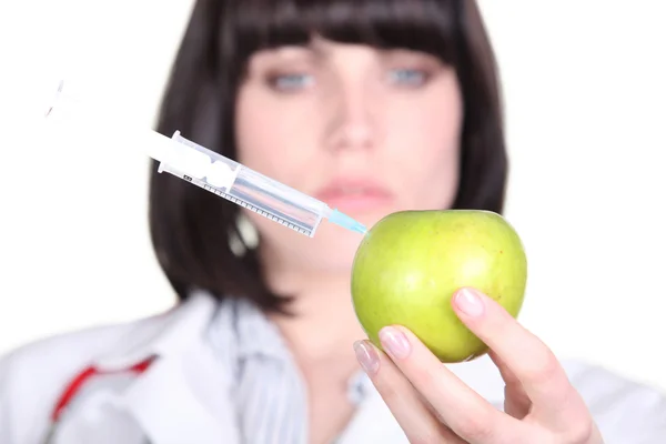 Medico con siringa in una mela — Foto Stock
